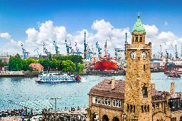 Beautiful view of famous Hamburger Landungsbruecken with harbor and traditional paddle steamer on Elbe river, St. Pauli district, Hamburg, Germany