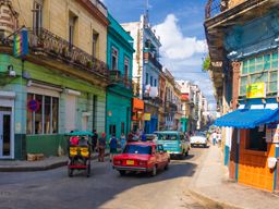 People and old cars in a central street in Havana, Cuba