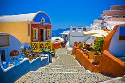 Typical and amazing colorful street in Oia city, Santorini, Greece