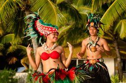 Polynesian Pacific Island Tahitian dancers on tropical beach during sunset