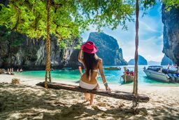 A girl relaxing on swing under tree, Lao Lading island, Andaman sea