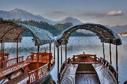 Boats on the shore of Lake Bled (Slovenia) and Castle Bled in the background
