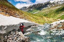 A woman with backpack climbing the mountain, Altai, Russia